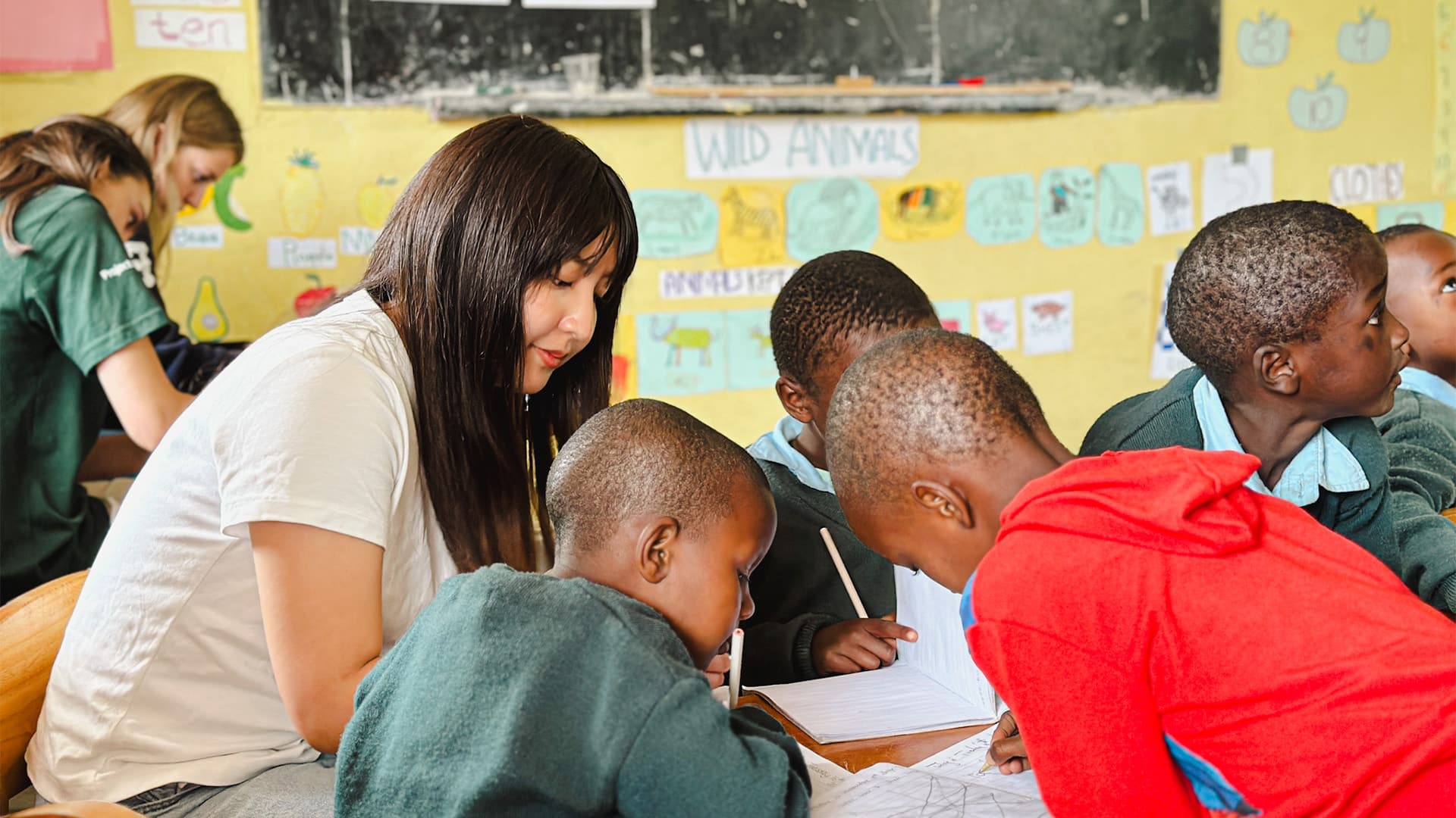 Maasai school Volunteer helping the children with school-work.