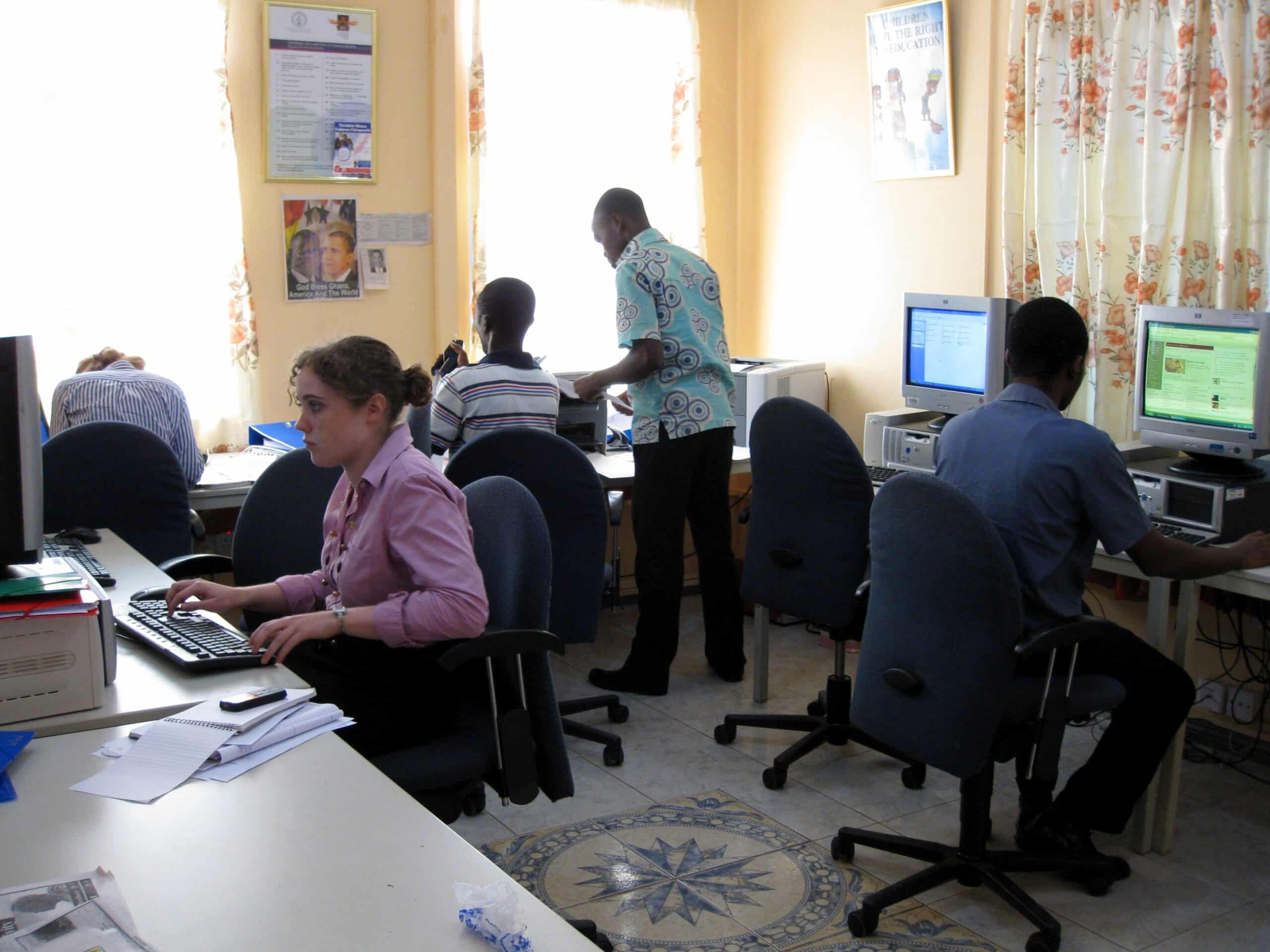 A volunteer teaching computer skills to a student in Ghana