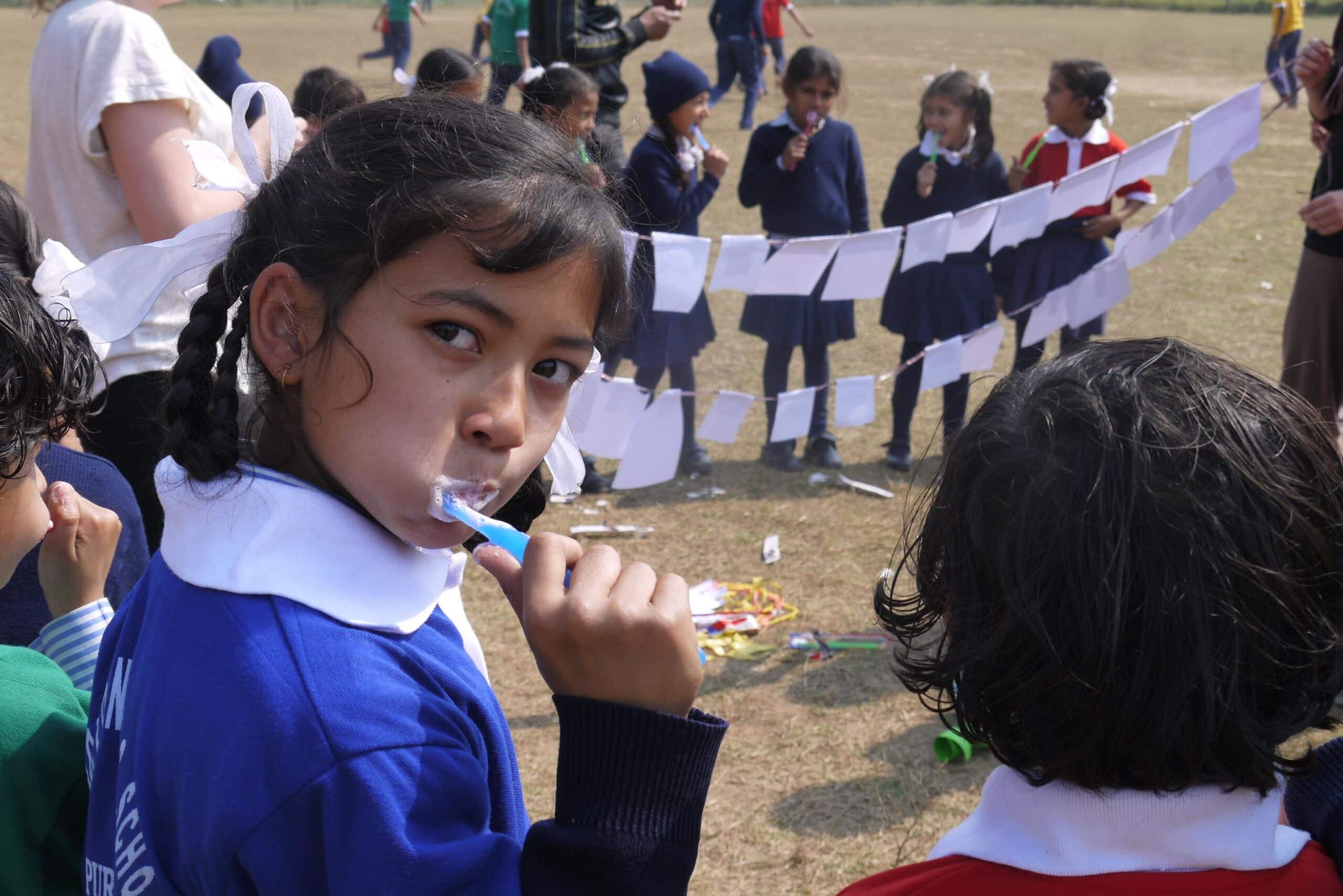 A child brushes her teeth outside a school during a hygiene workshop run by Projects Abroad Dentistry interns in Nepal.