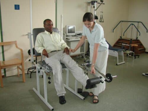 Female intern from Projects Abroad giving phsyiotherapy to a local man during her physiotherapy work experience in Ghana.