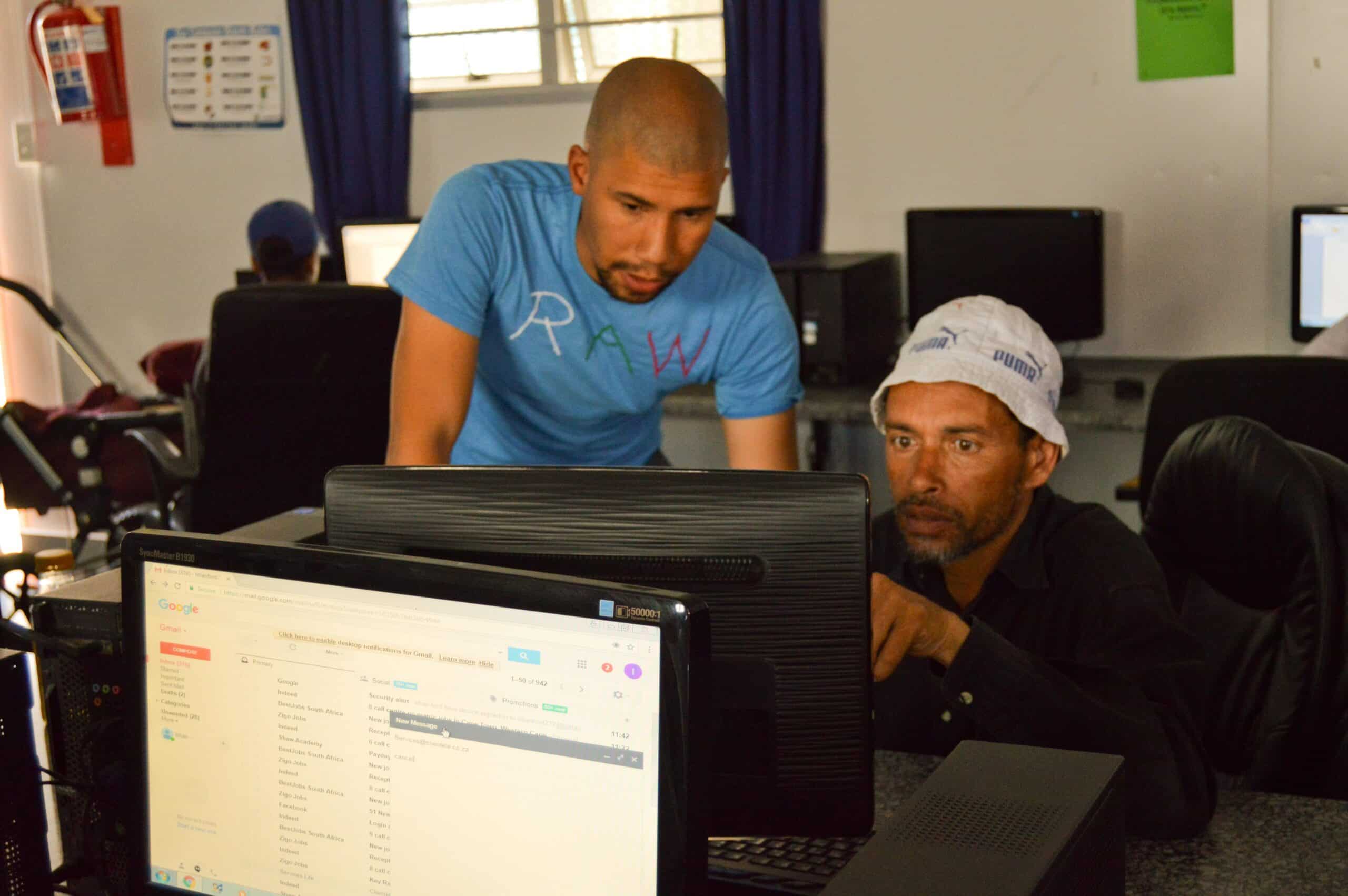Volunteer helping a students with his assignment during IT teaching experience in South Africa