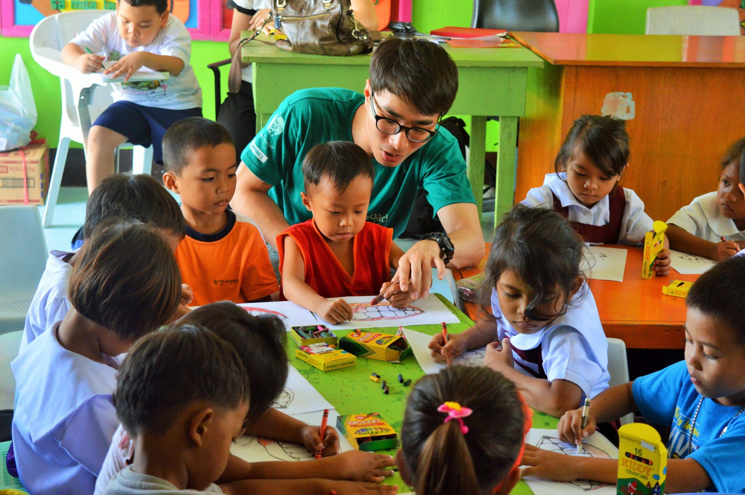 Students colour in a worksheet while learning about dental hygiene from a Projects Abroad volunteer teaching in the Philippines.