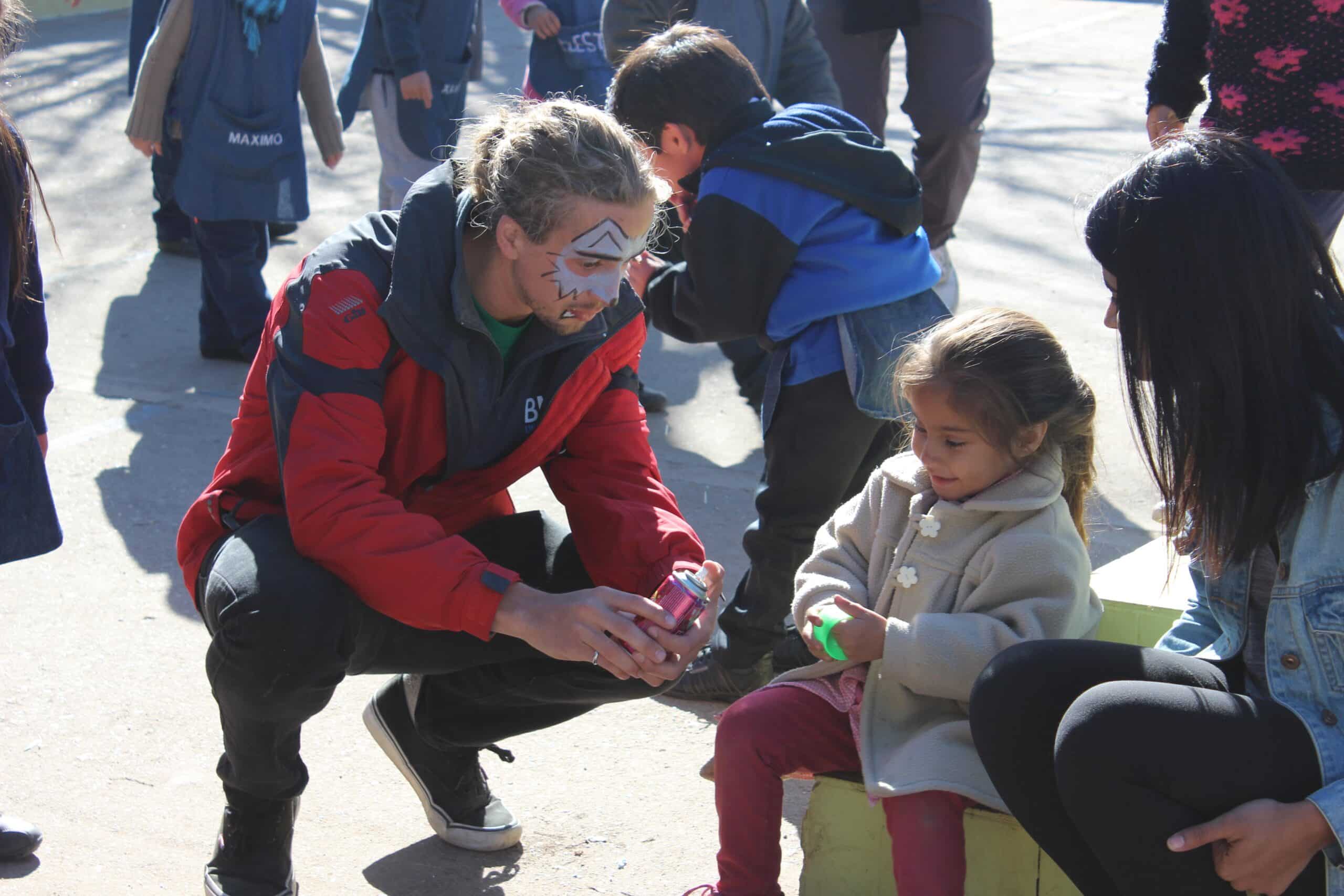 Projects Abroad volunteers interact with a child in Argentina during a community day at a local care centre.