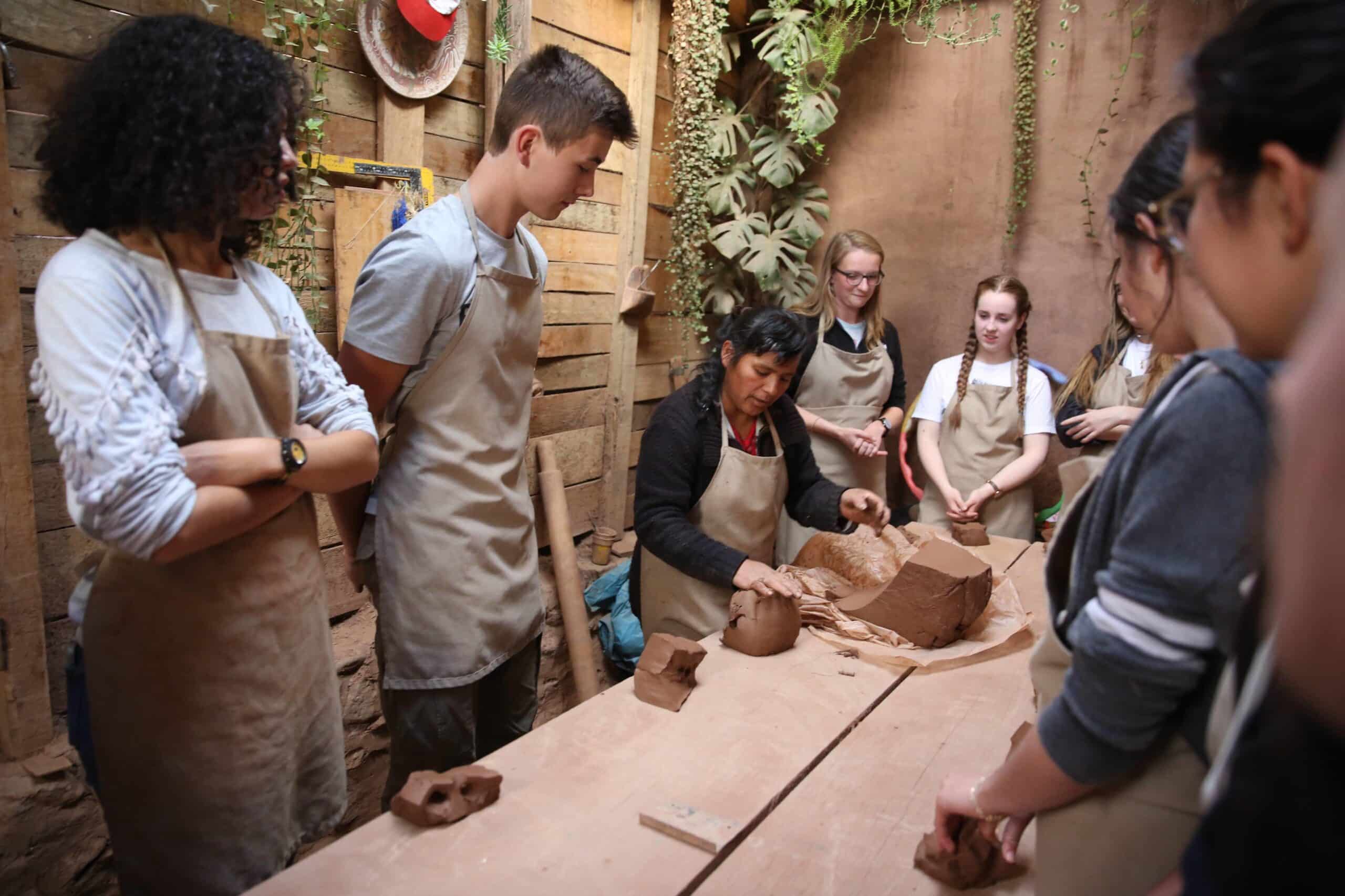 Volunteers learn about clay during a workshop as part of their community volunteer work in Peru for teenagers.