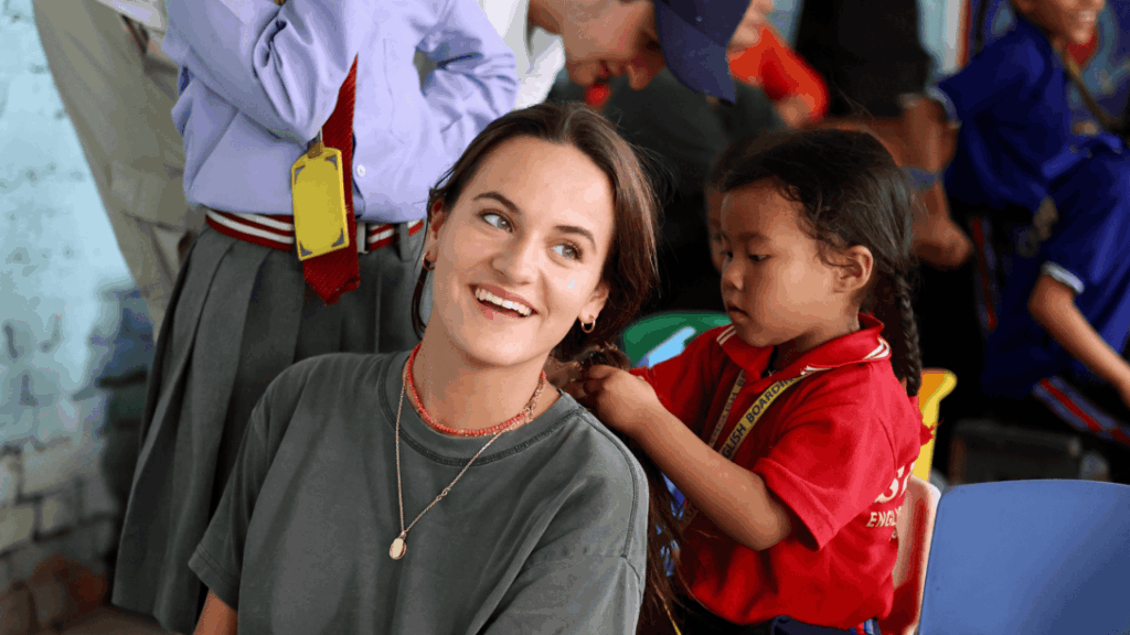 A group of Projects Abroad volunteers in traditional Peruvian clothing A child braiding a volunteer's hair in Nepal